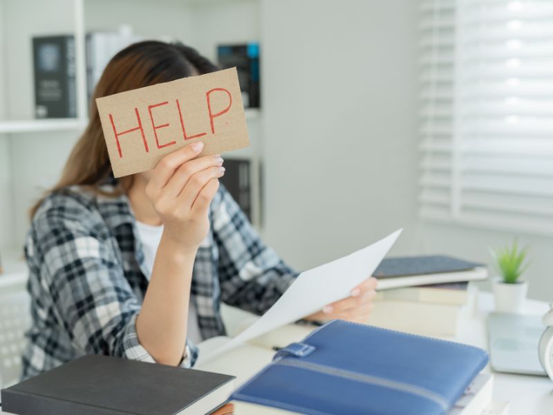 studentessa con cartello help a indicare la situazione del mercato degli affitti per studenti in Italia